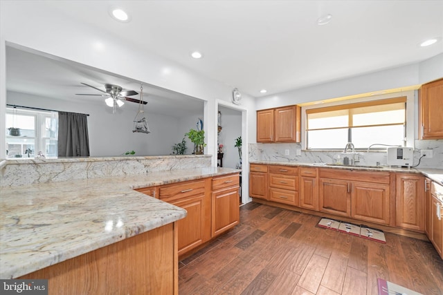 kitchen with decorative backsplash, ceiling fan, plenty of natural light, and light stone countertops