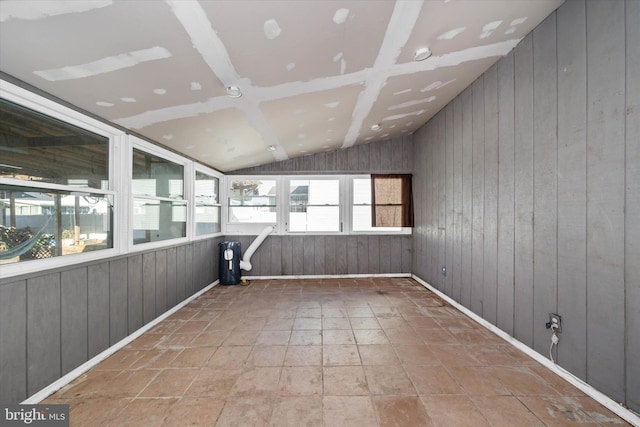 unfurnished sunroom featuring vaulted ceiling