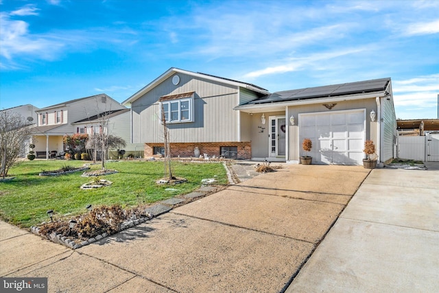 view of front of house featuring a front yard, a garage, and solar panels