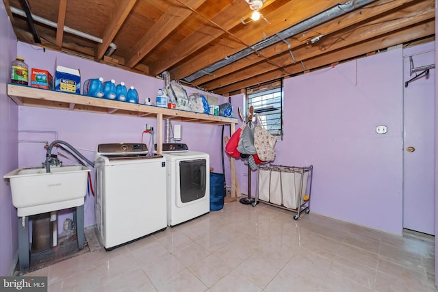 clothes washing area with sink, washer and clothes dryer, and light tile patterned floors