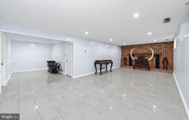 unfurnished living room with a brick fireplace and brick wall