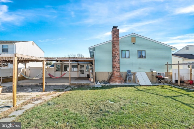 back of property with a patio area and a yard