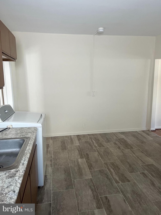 clothes washing area with cabinets, sink, and washing machine and dryer