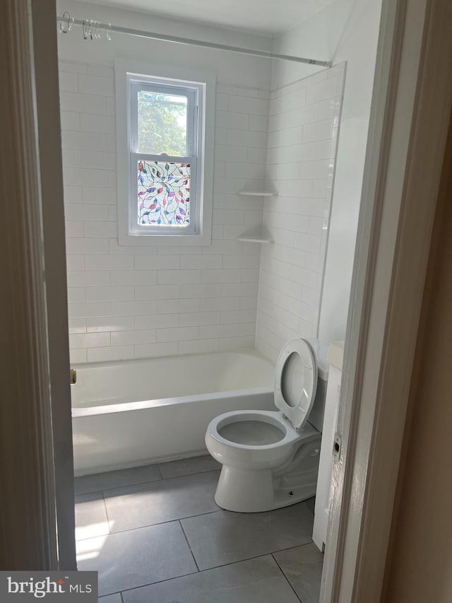 bathroom with tile patterned flooring, toilet, and tiled shower / bath