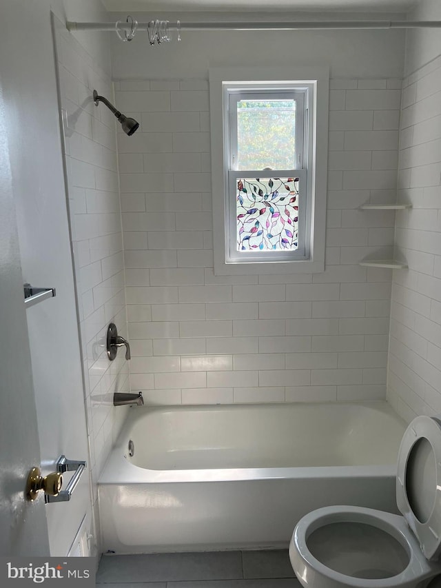 bathroom with tiled shower / bath combo and toilet