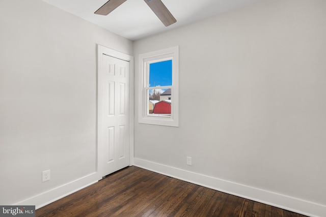 spare room with ceiling fan and dark wood-type flooring