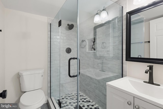 bathroom featuring vanity, toilet, and a shower with shower door