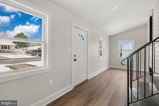 foyer entrance featuring dark wood-type flooring and vaulted ceiling