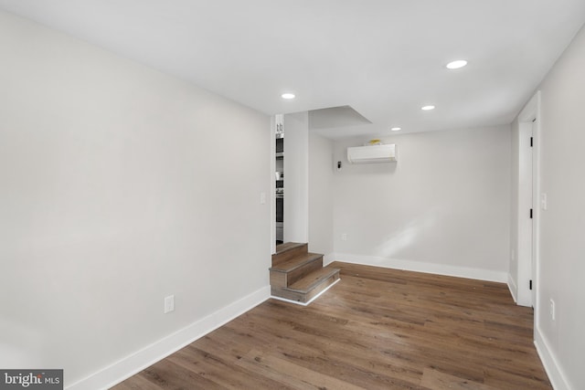 interior space with dark hardwood / wood-style flooring and a wall mounted air conditioner