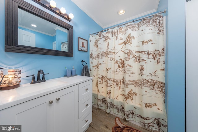 bathroom featuring hardwood / wood-style flooring, vanity, ornamental molding, and shower / bathtub combination with curtain