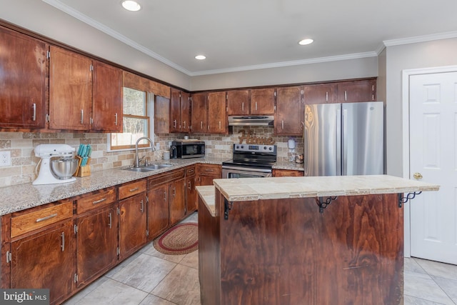 kitchen featuring a kitchen breakfast bar, a kitchen island, sink, and appliances with stainless steel finishes