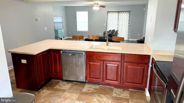 kitchen with stove, sink, stainless steel dishwasher, ceiling fan, and kitchen peninsula