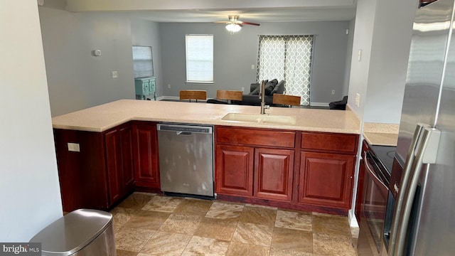 kitchen featuring ceiling fan, sink, kitchen peninsula, and stainless steel appliances