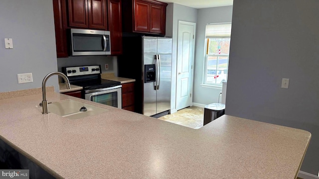 kitchen with sink, kitchen peninsula, and stainless steel appliances