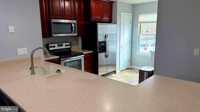 kitchen featuring kitchen peninsula, stainless steel appliances, and sink