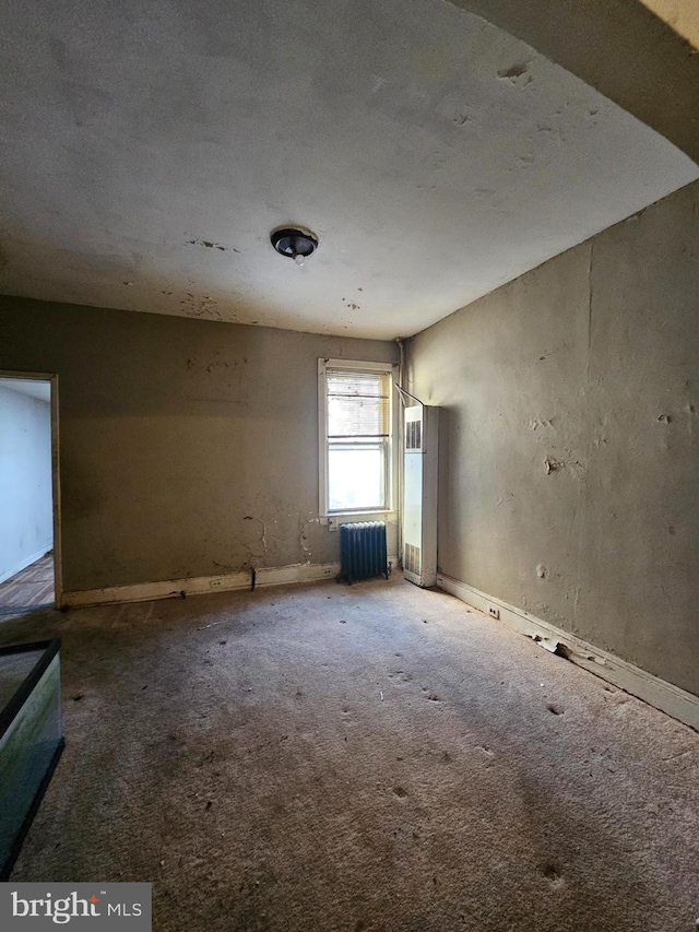 carpeted empty room with radiator heating unit