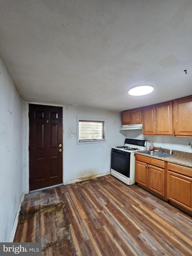 kitchen with dark hardwood / wood-style flooring, white range with gas stovetop, and sink