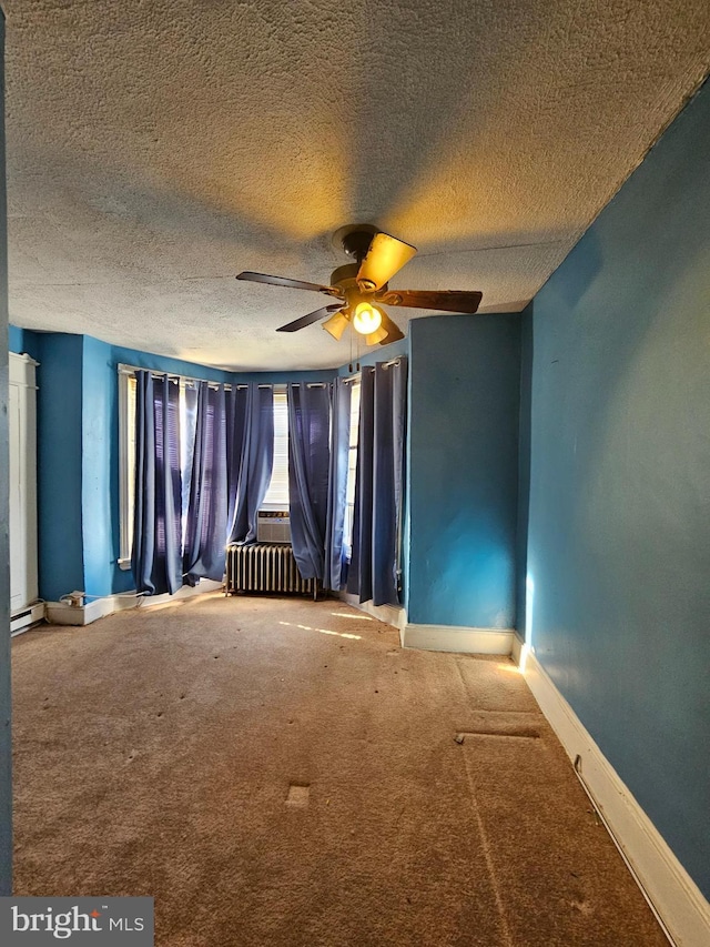 carpeted spare room featuring radiator heating unit, a textured ceiling, a baseboard radiator, and ceiling fan