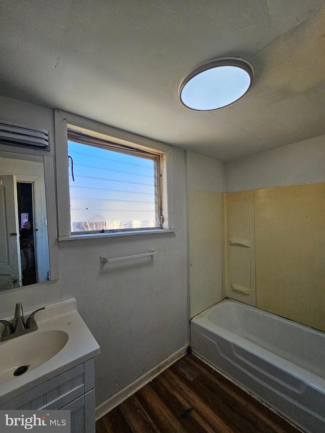 bathroom featuring hardwood / wood-style floors, vanity, and shower / bathtub combination