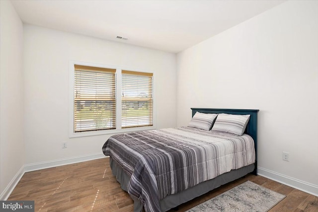 bedroom with dark hardwood / wood-style flooring