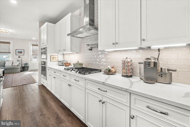 kitchen featuring white cabinetry, wall chimney exhaust hood, light stone counters, dark hardwood / wood-style floors, and stainless steel gas stovetop