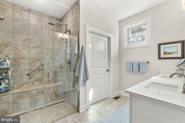 bathroom with tile patterned flooring, vanity, and walk in shower