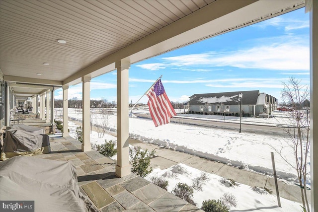 snow covered patio with a grill