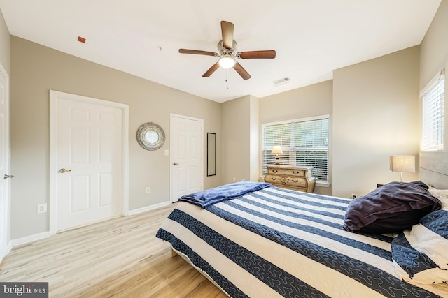 bedroom featuring multiple windows, ceiling fan, and light wood-type flooring