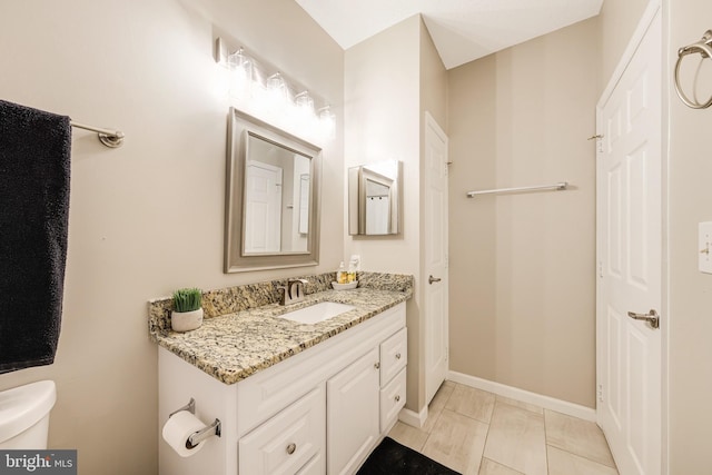 bathroom featuring tile patterned flooring, vanity, and toilet