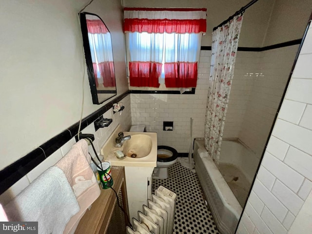 full bathroom with vanity, toilet, tile walls, and radiator heating unit