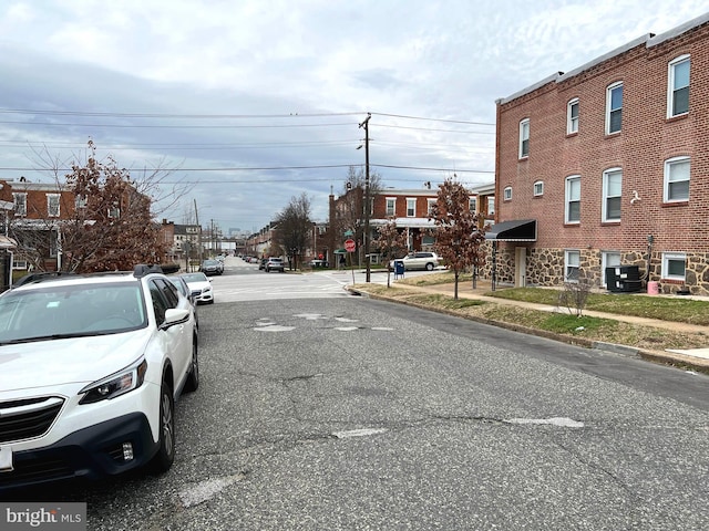 view of street featuring curbs, traffic signs, and sidewalks