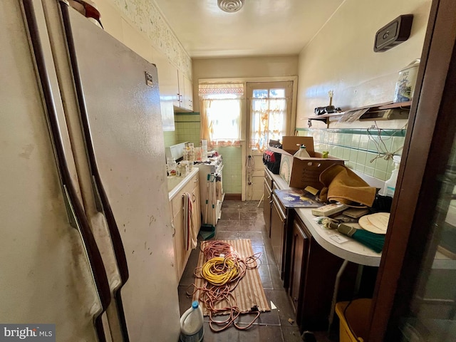 kitchen featuring gas stove, light countertops, and freestanding refrigerator