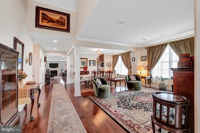 living room featuring ornamental molding, dark hardwood / wood-style flooring, and ornate columns