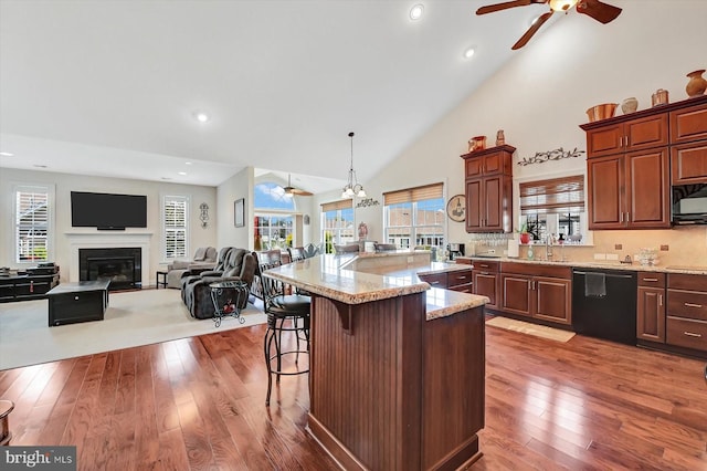 kitchen with a kitchen island, a breakfast bar, pendant lighting, dark hardwood / wood-style floors, and black appliances