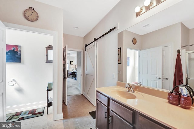 bathroom featuring tile patterned flooring, vanity, and a shower