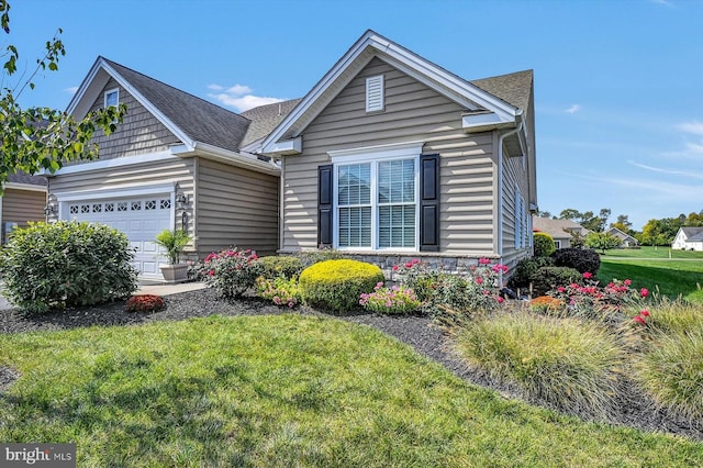 view of front of property featuring a garage and a front lawn