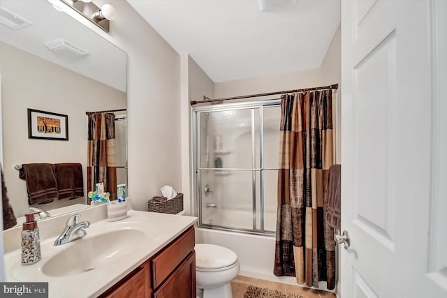 full bathroom with vanity, bath / shower combo with glass door, tile patterned floors, and toilet