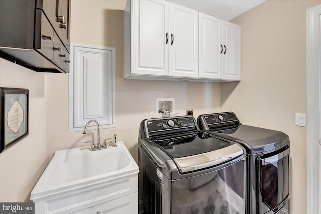 laundry room featuring cabinets, washing machine and dryer, and sink