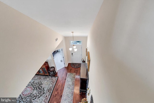 doorway featuring an inviting chandelier and dark wood-type flooring