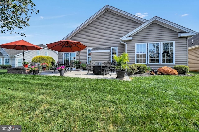 rear view of house with a lawn and a patio