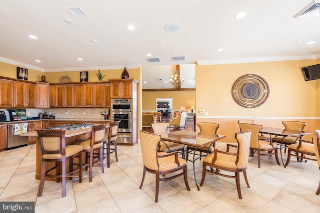 dining space featuring an inviting chandelier, ornamental molding, and light tile patterned floors