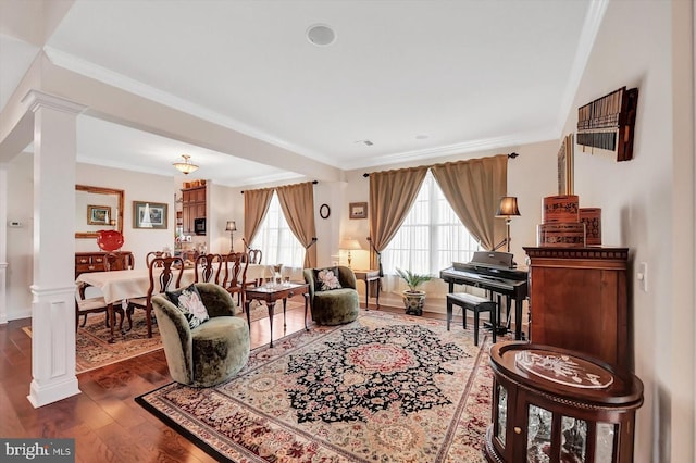 living room featuring crown molding, dark hardwood / wood-style flooring, and ornate columns