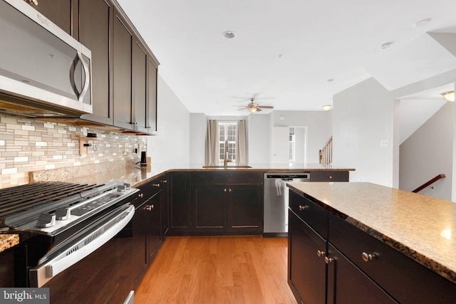 kitchen with appliances with stainless steel finishes, tasteful backsplash, sink, ceiling fan, and light hardwood / wood-style flooring