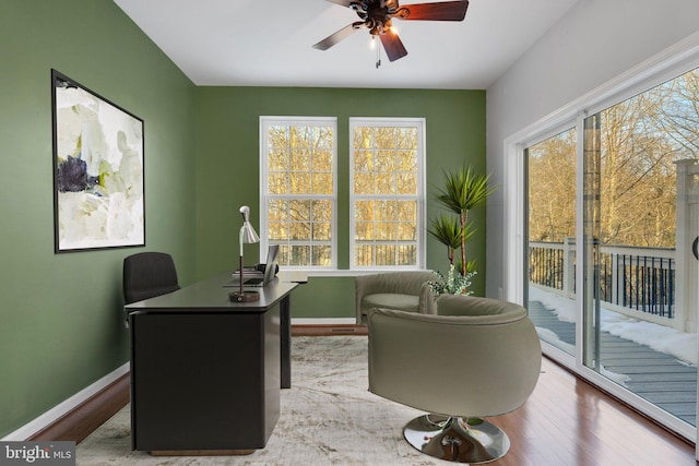 office with light wood-type flooring and ceiling fan