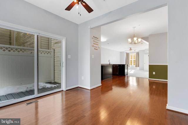 unfurnished room featuring ceiling fan with notable chandelier, hardwood / wood-style floors, and sink