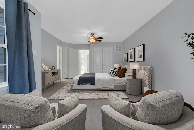 bedroom with ceiling fan, a closet, and carpet flooring