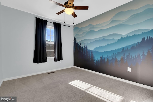 empty room featuring ceiling fan and carpet flooring