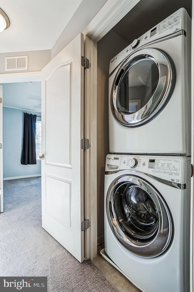 laundry room featuring stacked washing maching and dryer and carpet flooring