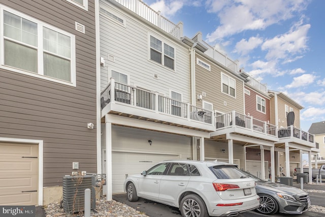 exterior space with central AC unit and a garage