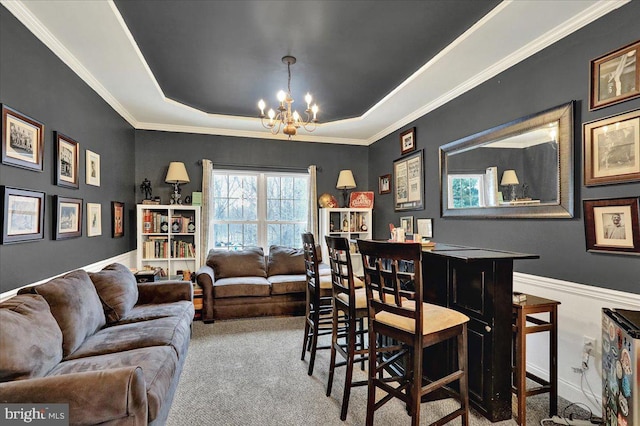 dining area with a notable chandelier, light colored carpet, ornamental molding, and a tray ceiling